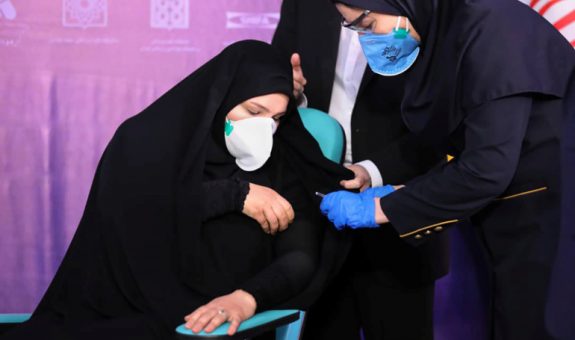 A nurse prepares to inject a volunteer taking part in an Iranian coronavirus disease (COVID-19) vaccine trial in Tehran
